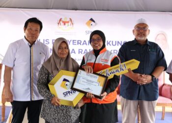 AIMAN Athirah Sabu menyerahkan kunci Rumah Mesra Rakyat kepada penerima di Rancangan Tanah Berkelompok Kampung Baru di Kemasik, Kemaman Terengganu. - UTUSAN/NIK NUR IZZATUL HAZWANI NIK ADNAN