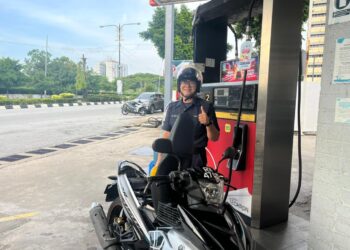 ANTARA anggota Polis Diraja Malaysia (PDRM) terawal yang menggunakan inisiatif subsidi petrol Budi Madani RON95 (BUDI95) di stesen minyak sekitar Kuala Terengganu. - UTUSAN / NURSYASYA NADHIRAH ZABIDI