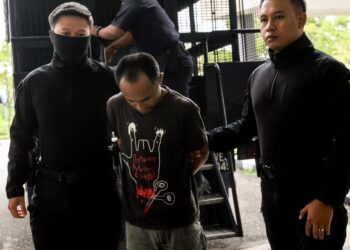 TERTUDUH semasa dibaw polis untuk prosiding perbicaraan di Mahkamah Sesyen Kota Bharu, Kelantan. - UTUSAN/KAMARUL BISMI KAMARUZAMAN.