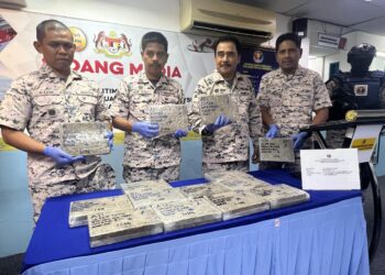 ROMLI Mustafa (tiga dari kiri) menunjukkan ketulan mampat ganja yang dirampas menerusi rondaan di kedudukan 0.7 batu nautika dari persisir Kuala Sanglang, Kangar, Perlis, awal pagi tadi. -UTUSAN/ASYRAF MUHAMMAD