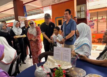 MOHD. Dusuki Mokhtar (dua dari kanan) menyampaikan sumbangan kepada murid yang terpilih pada Majlis Peluncuran Sekolah Angkat Malaysia Madani di Sekolah Kebangsaan Long Gafar, Kota Bharu, Kelantan. - UTUSAN/ ROSLIZA MOHAMED
