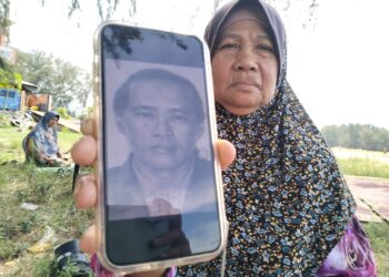 CHE Bunga Yaakob menunjukkan gambar suaminya Ahmad Hussien yang hilang di laut ketika ditemui di Pantai Geting Pengkalan Kubor Tumpat, Kelantan-UTUSAN/ ROHANA ISMAIL.