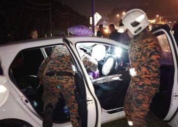 ANGGOTA Balai Bomba dan Penyelamat Ayer Hitam melakukan kerja-kerja mengeluarkan seorang wanita yang tersepit di tempat duduk penumpang hadapan kereta Produa Axia selepas terlibat kemalangan dengan kenderaan pelbagai guna Toyota Velfire malam tadi.