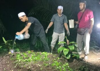 AHLI keluarga menyiram air di atas kubur Nurul Nur Syamira Khamis selepas pengebumian di Kampung Sungai Protan, Selinsing di Bagan Serai malam ini. - UTUSAN/WAT KAMAL ABAS