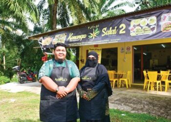 Pasangan suami isteri , Che Ku Zulhilmi Che Ku Shamsudeen dan Nor Azwani Zakaria di hadapan kedai makan mereka, Kenanga Salai 2.