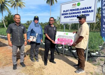 MOHAMAD Zabawi Abdul Ghani (tiga dari kiri) menyerahkan replika Geran Usahawan Perintis bernilai RM140,000 kepada Mohd Fauzi (kanan) di Kampung Beris Lalang, Bachok, Kelantan.