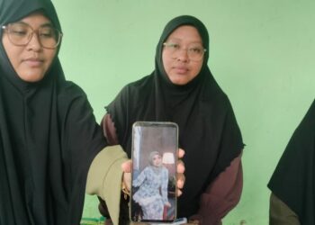 HAMIDAH Khalid ((kiri) dan keluarganya menunjukan gambar Nurul Nur Syamira Khamis ketika ditemui di  Kampung Sungai Perotan, Selinsing  di Bagan Serai. - UTUSAN