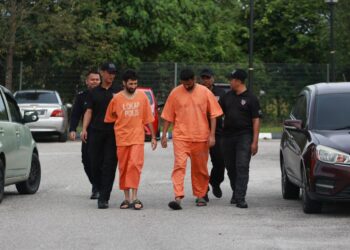 KEDUA-dua tertuduh diiringi polis semasa menghadiri prosiding perbicaraan di Mahkamah Sesyen, Kota Bharu, Kelantan. - UTUSAN/KAMARUL BISMI KAMARUZAMAN