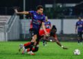 Pemain PDRM, Hadi Fayyadh (kiri), mengasak pemain Kelantan The Real Warriors, pada perlawanan Liga Super 2025/2026, Stadium Majlis Perbandaran Selayang, di sini semalam. - UTUSAN/SHIDDIEQIIN ZON