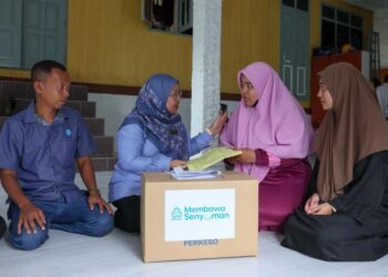 SUHARA Mustaffa (dua dari kiri) menyampaikan bantuan Perkeso kepada Nur Nabilah Abdul Rahim (dua dari kanan) dan kakaknya Nur Nadhirah di Kampung Pulau Kerengga, Marang, Terengganu. - UTUSAN/PUQTRA HAIRRY