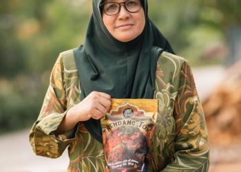 PENGASAS Yeop Food Industries Enterprise, Nora'ashah Ibrahim menunjukkan Rendang Tok Kayu Api keluaran syarikatnya.