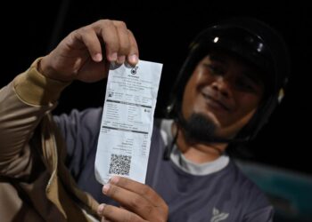 SAIFUL Lizam menunjukkan resit pembelian minyak subsidi petrol RON95 pada harga RM1.99 seliter berbanding harga pasaran semasa RM2.60 seliter ketika tinjauan di Stesen Minyak Petronas Tok Jamal, Kuala Terengganu malam tadi. - UTUSAN/PUQTRA HAIRRY