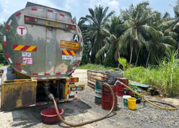 ANTARA kenderaan dan barangan memindahkan minyak sawit untuk pasaran gelap  yang dirampas dalam serbuan di sebuah bengkel di Sitiawan, semalam. - IHSAN PPM