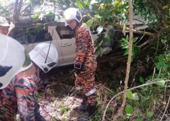 ANGGOTA Balai Bomba dan Penyelamat (BBP) Tenom bertindak menyelamatkan mangsa lelaki warga emas yang tersepit di tempat duduk pemandu. - IHSAN BBP TENOM