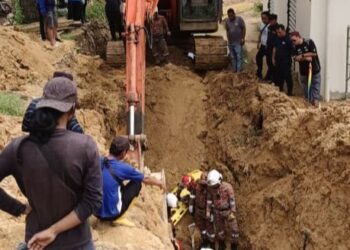 ANGGOTA Balai Bomba dan Penyelamat (BBP) Kota Kinabalu menjalankan operasi menggali tanah menggunakan jengkaut bagi mengeluarkan mangsa. - IHSAN BBP KOTA KINABALU