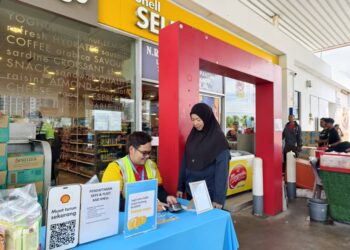 RUSIAH Ahmad melihat kakitangannya menjaga kaunter khas bagi pelaksanaan BUDI95 membabitkan warga ATM serta PDRM stesen minyak tersebut di Port Dickson hari ini. UTUSAN/ NOR AINNA HAMZAH