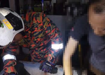 ANGGOTA bomba membantu lelaki yang  tangan tersepit pada mesin pengisar dalam kejadian di Chemor, Ipoh.