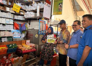 AZMAN Ismail (tiga dari kanan) menyerahkan pelekat Pasar Patuh kepada peniaga ayam di Pasar Sumayyah Tumpat , Kelantan. - UTUSAN/ ROSLIZA MOHAMED