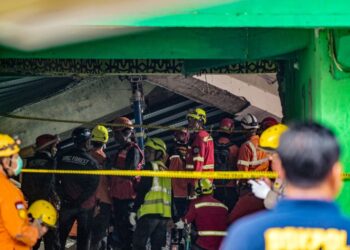 Anggota penyelamat mencari mangsa yang terselamat di pondok pesantren Al Khoziny di Sidoarjo, wilayah Jawa Timur pada 30 September 2025, selepas bangunan bertingkat di sekolah itu runtuh. - AFP