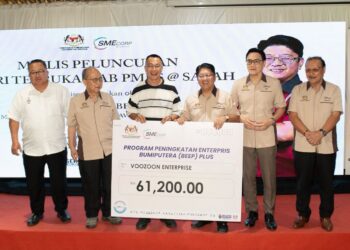 Ewon Benedick (empat, kiri) menyampaikan geran Program Peningkatan Interpris Bumiputera (BEEP) Plus kepada penerima.  - IHSAN KUSKOP