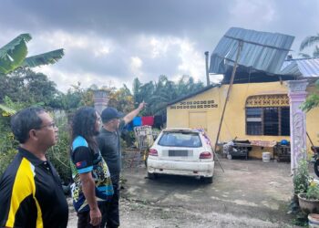JASNI Sapuan (tengah) bersama Yusla Ismail (kanan) melihat keadaan bumbung rumah yang rosak dilanda angin kencang di Parit Lapis Mahang, Senggarang, Batu Pahat, Johor, semalam.