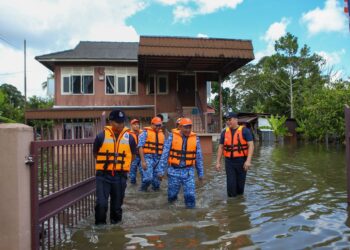 MOHD. Bukhori Mat Sidik (tengah) bersama anggota APM dan polis meninjau keadaan rumah mangsa banjir di Jalan Makam Diraja Langgar, Alor Setar hari ini. UTUSAN/ SHAHIR NOORDIN