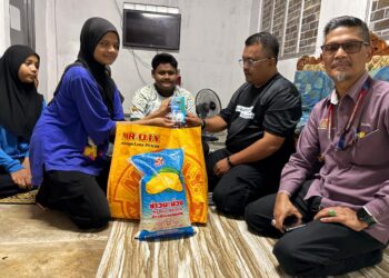 ZAINUDDIN Ghazali (dua dari kanan) menyerahkan bakul makanan dan sumbangan kepada Nur Zulaiha Zainuddin di Kampung Padang Bongor, Kota Bharu, Kelantan. – UTUSAN/ROSLIZA MOHAMED