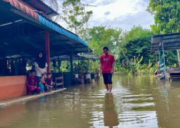 MOHD. Zamri Zaidin meranduk air di kawasan halaman rumahnya yang mengalami banjir termenung sejak Sabtu lepas di Kampung Pokok Asam, Langgar, Alor Setar.