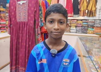 M. Mitharshan tersenyum ketika ditemui selepas program pembelian pakaian baharu di Little India, Banda Hilir, Melaka.