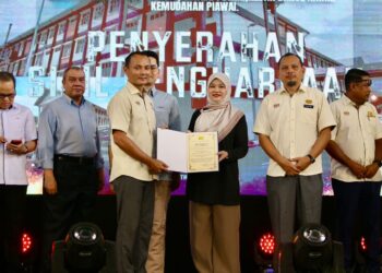 FADHLINA Sidek menyampaikan sijil penghargaan kepada salah seorang wakil Jabatan Kerja Raya (JKR) ketika Majlis Penyerahan Projek SMK Bandar Baru Sungai Lalang di Ambangan Heights, hari ini. - UTUSAN/SHAHIR NOORDIN