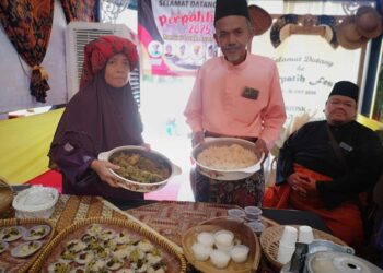 ISMAIL Shamsudin (berdiri kanan) menunjukkan rendang maman burung puyuh yang merupakan masakan istimewa masyarakat setempat dari Luak Air Kuning. – UTUSAN/NUR SHARIEZA ISMAIL