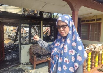 RUMAIZAH Abd. Manaf menunjukkan keadaan rumah pusaka keluarganya yang musnah dalam kebakaran Kampung Bagan Nira, Sabak, Sabak Bernam, Selangor