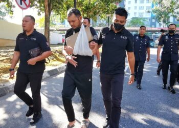 MOHAMAD Halikhwan Halbahri  dibawa ke mahkamah hari ini dengan tangan kirinya diikat kain anduh bagi berdepan pendakwaan atas tujuh pertuduhan meragut barang kemas beberapa mangsa wanita di sekitar daerah Seremban sejak tahun lalu.-UTUSAN/MOHD. SHAHJEHAN MAAMIN.