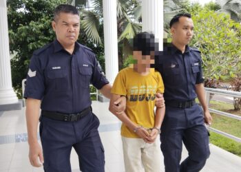 TERTUDUH diiringi anggota polis ketika dihadapkan ke Mahkamah Sesyen, Alor Gajah, Melaka atas pertuduhan melakukan amang seksual fizikal. - UTUSAN/MUHAMMAD SHAHIZAM TAZALI