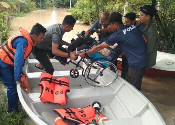 SEORANG penduduk yang berkerusi roda dipindahkan ke PPS ekoran banjir melanda Kampung Manggis di Kulim, Kedah. - IHSAN APM