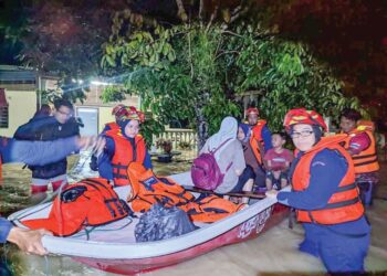 ANGGOTA  Pertahanan Awam membantu mangsa banjir di Kedah berpindah ke pusat pemindahan sementara.