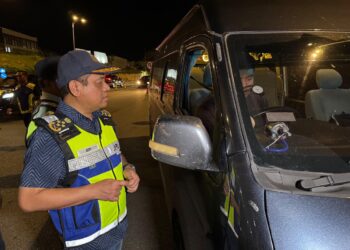 AEDY Fadly Ramli memeriksa dokumen pemandu van persiaran yang dikenal pasti melakukan kesalahan mengubah suai kenderaan semasa Op Gempur di Plaza Tol Sungai Petani Utara, Kedah, semalam.