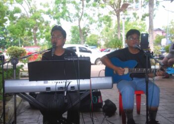 MUHD. Hafizam Zaidon (kiri) dan Amirul Amin melakukan persembahan di kaki lima Medan Selera Masjid Al-Alami, Ayer Keroh, Melaka. – UTUSAN/AMRAN MULUP