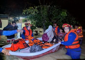 ANGGOTA Angkatan Pertahanan Awam (APM) Kulim mengeluarkan mangsa terperangkap di rumah dalam kejadian banjir di Kampung Jeram, Kulim. - IHSAN APM