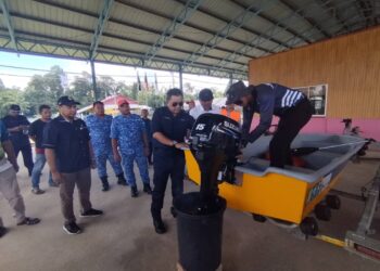 AZAMUDDIN Ahmad @Abu (tengah) ketika memeriksa keadaan bot yang bakal digunakan untuk operasi menyelamat ketika banjir di Taman Rekreasi Agro Darau, Besut, Terengganu. - UTUSAN / WAN ZURATIKAH IFFAH WAN ZULKIFLI
