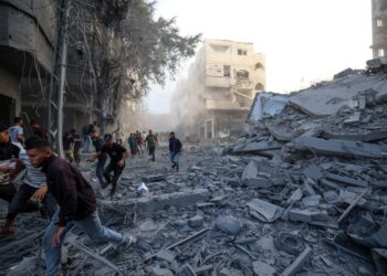 ORANG ramai berlari menyelamatkan diri selepas serangan Israel menyasarkan sebuah bangunan di kem Bureij, di tengah Gaza, pada Ahad lalu.- AFP