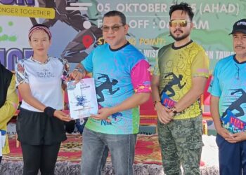 Nizam (tiga dari kiri) menyampaikan hadiah kepada peserta Civil Defence Fun Run. - GAMBAR/BESSE AISYAH