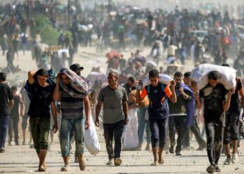 RAKYAT Palestin membawa bantuan yang diterima dari pusat agihan GHF di koridor Netzarim, Nuseirat, tengah Gaza, pada 30 September lalu.- AFP