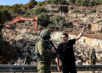 SEORANG penunjuk perasaan Palestin (kanan) berdebat dengan tentera rejim di tapak pembinaan jalan baharu untuk peneroka Israel berhampiran kampung Beit Ur al-Fauqa di Tebing Barat. – AFP
