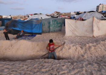 SEORANG kanak-kanak Palestin menggali halangan pasir di kawasan penempatan tepi pantai di selatan Gaza. – AGENSI