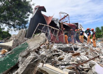 PASUKAN penyelamat mencari mangsa di bawah runtuhan sebuah bangunan di Bogo City, tengah Filipina.-AFP