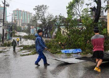 PENDUDUK mengalihkan sebahagian bumbung rumah yang tercabut akibat Taufan Melissa di Santiago de Cuba, Cuba. – AFP
