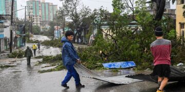 PENDUDUK mengalihkan sebahagian bumbung rumah yang tercabut akibat Taufan Melissa di Santiago de Cuba, Cuba. – AFP
