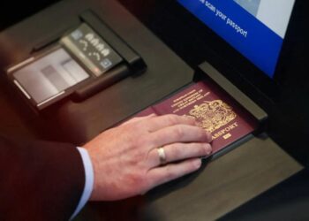SEORANG lelaki mengimbas pasportnya semasa demonstrasi Sistem EES Kesatuan Eropah di terminal Eurotunnel di Folkestone, Britain.-AGENSI