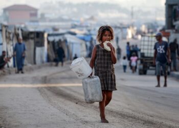 SEORANG kanak-kanak perempuan Palestin berjalan kaki sambil makan roti di Deir al-Balah di tengah Gaza. – AFP